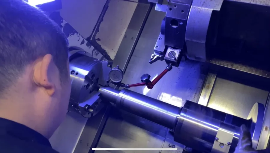 CNC lathe cutting a shaft in the Migreat workshop